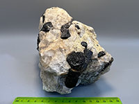 a chunk of crystalline rock with large pink, white, and black crystals
